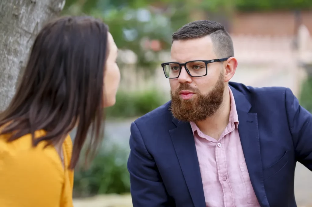 Deux collègues échangent en extérieur, illustrant l'importance du dialogue et de l'écoute active en entreprise pour préserver la santé mentale.